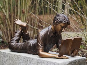 Tuinbeeld - bronzen beeld - Liggende lezende Jongen - 35 cm hoog Bronzartes